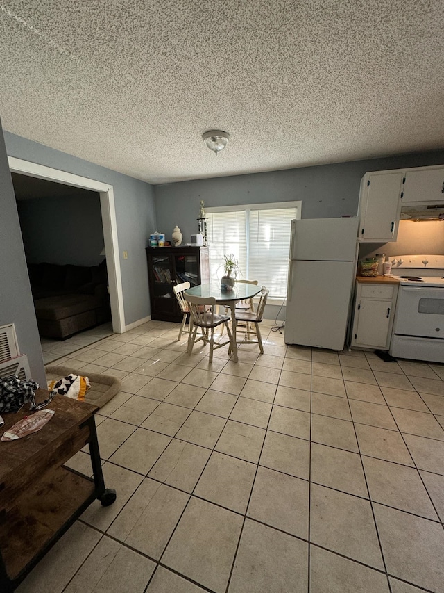 tiled dining space with a textured ceiling