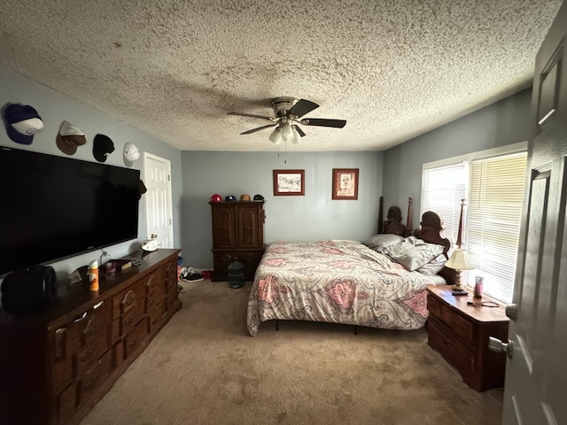 carpeted bedroom with ceiling fan and a textured ceiling