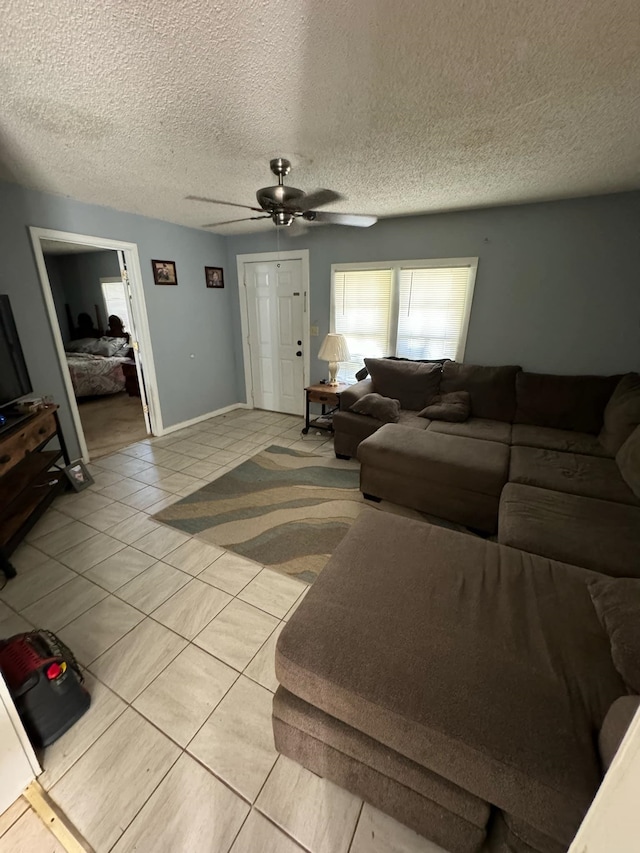 living room featuring ceiling fan and a textured ceiling