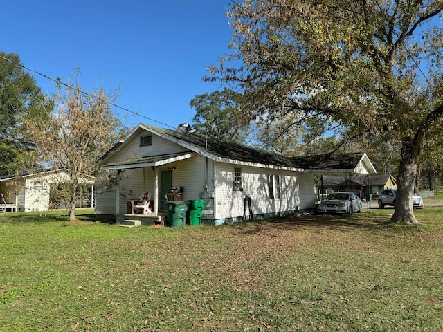 view of side of property featuring a yard and a carport