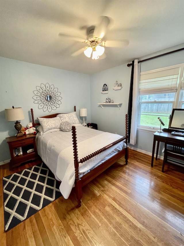 bedroom with wood finished floors, baseboards, and ceiling fan