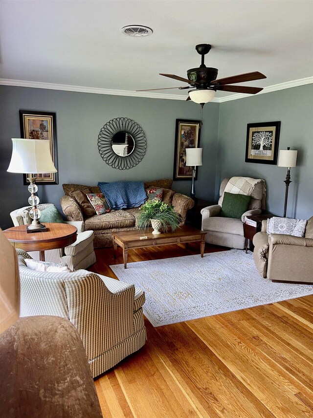 living area featuring crown molding, wood finished floors, and ceiling fan