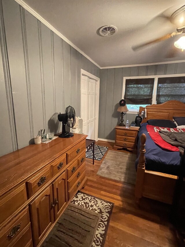 bedroom with wood-type flooring, ornamental molding, and a ceiling fan