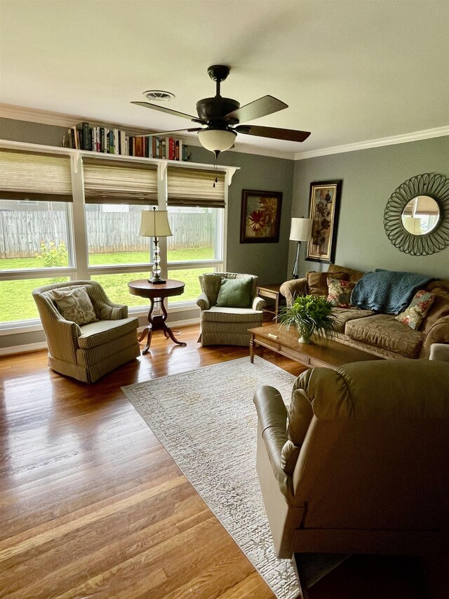 living room with ornamental molding, wood finished floors, and a ceiling fan