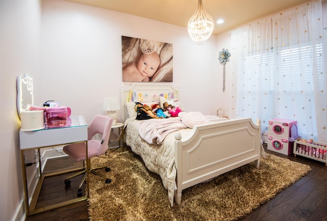 bedroom with wood-type flooring and a notable chandelier