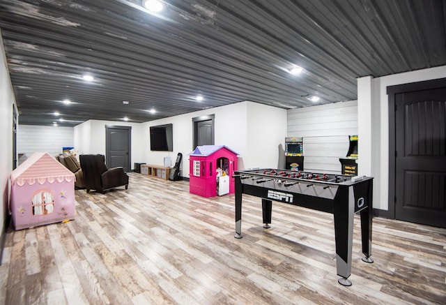 playroom with hardwood / wood-style floors and wood walls