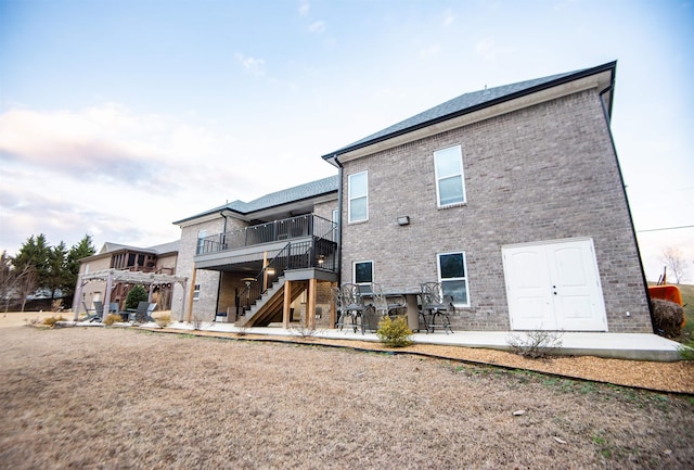 back of house with a balcony and a patio area