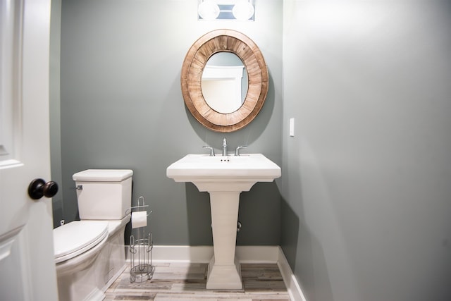 bathroom featuring hardwood / wood-style flooring and toilet