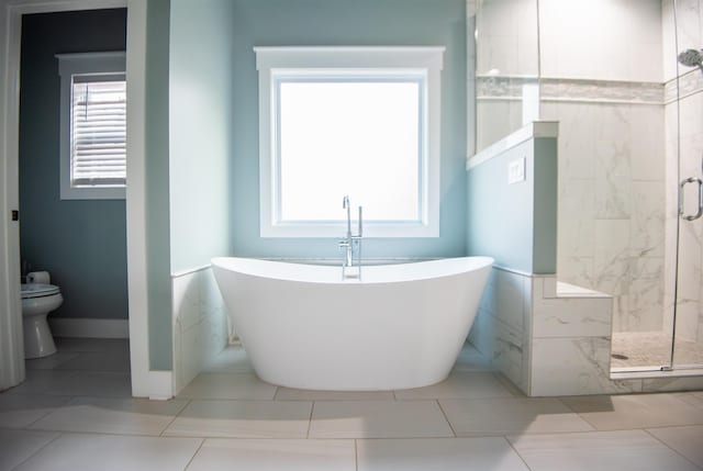 bathroom featuring shower with separate bathtub and toilet