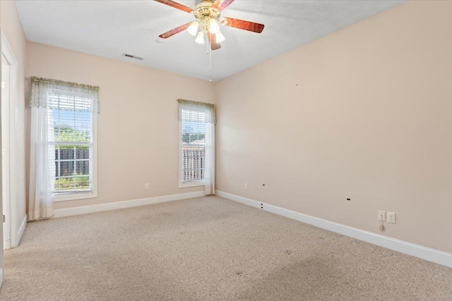 empty room with carpet floors, ceiling fan, and baseboards