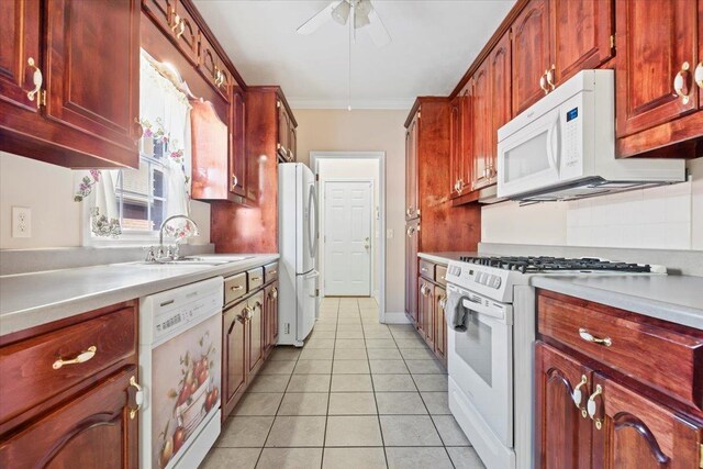 kitchen featuring white appliances, ceiling fan, light countertops, light tile patterned floors, and reddish brown cabinets