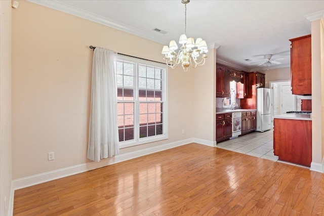 kitchen with white appliances, crown molding, light countertops, light wood-type flooring, and a chandelier