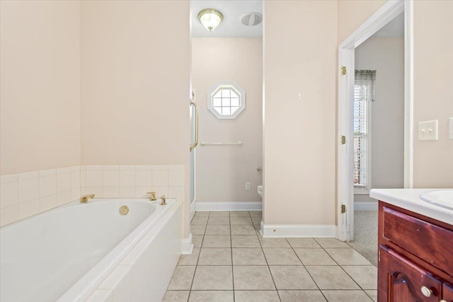 bathroom with a bath, plenty of natural light, vanity, and tile patterned floors