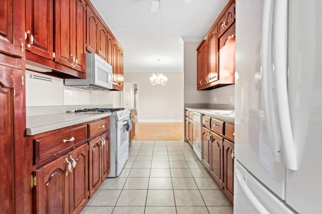 kitchen featuring white appliances, light countertops, pendant lighting, a chandelier, and crown molding