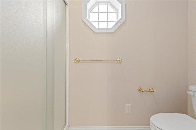 full bath featuring toilet and a stall shower