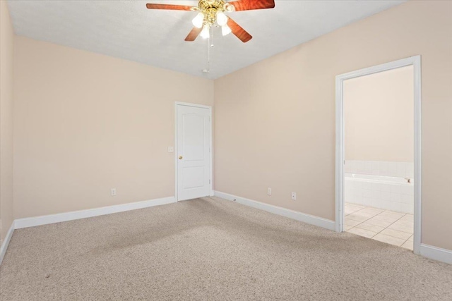 carpeted empty room featuring ceiling fan and baseboards