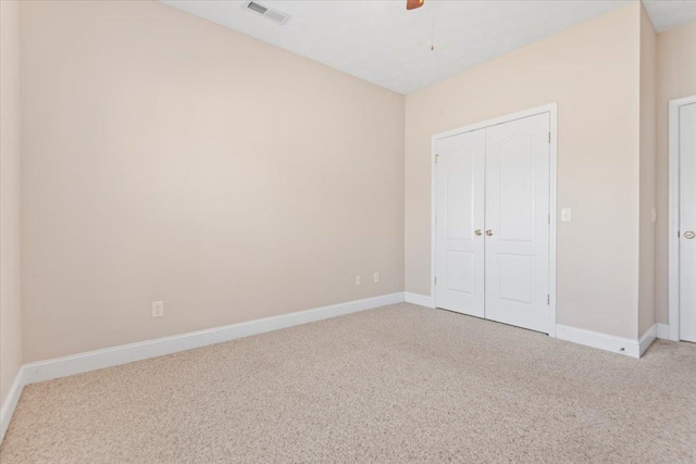 unfurnished bedroom featuring carpet floors, baseboards, a closet, and a ceiling fan