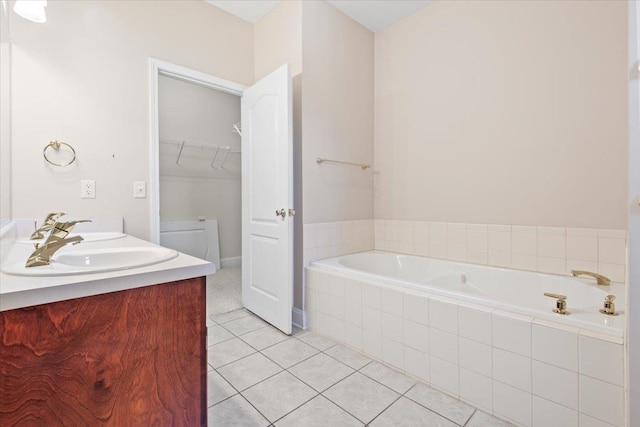 full bathroom with tile patterned flooring, a garden tub, double vanity, and a walk in closet