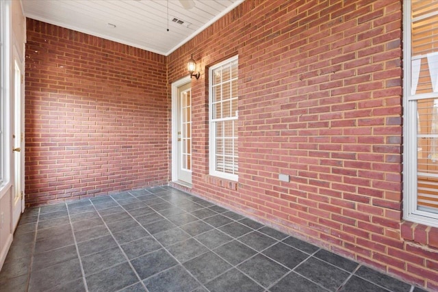 unfurnished sunroom featuring ceiling fan