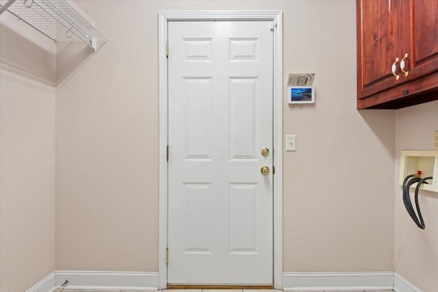 laundry room featuring cabinet space and baseboards