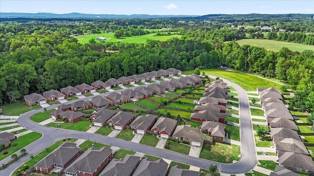 aerial overview of property's location featuring nearby suburban area and a heavily wooded area