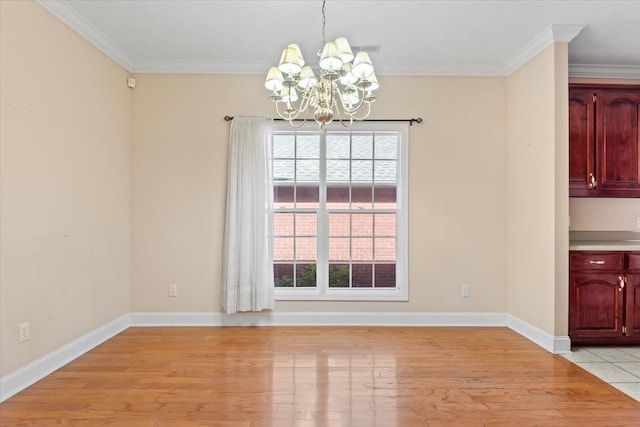 unfurnished dining area featuring a chandelier, light wood-type flooring, ornamental molding, and healthy amount of natural light