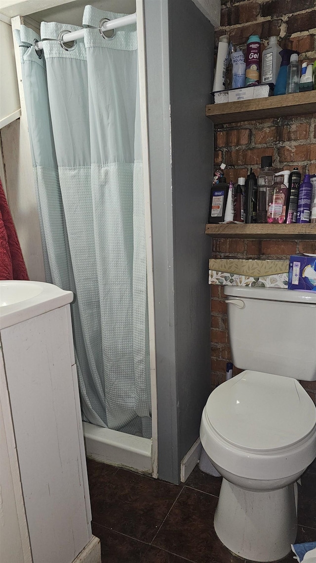 bathroom featuring tile patterned flooring, brick wall, toilet, and a shower with shower curtain