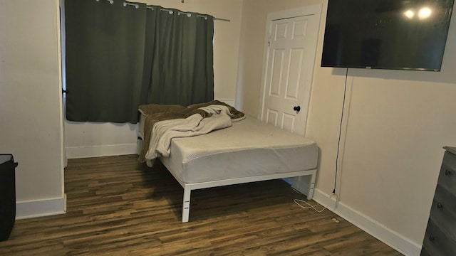 bedroom with dark hardwood / wood-style flooring