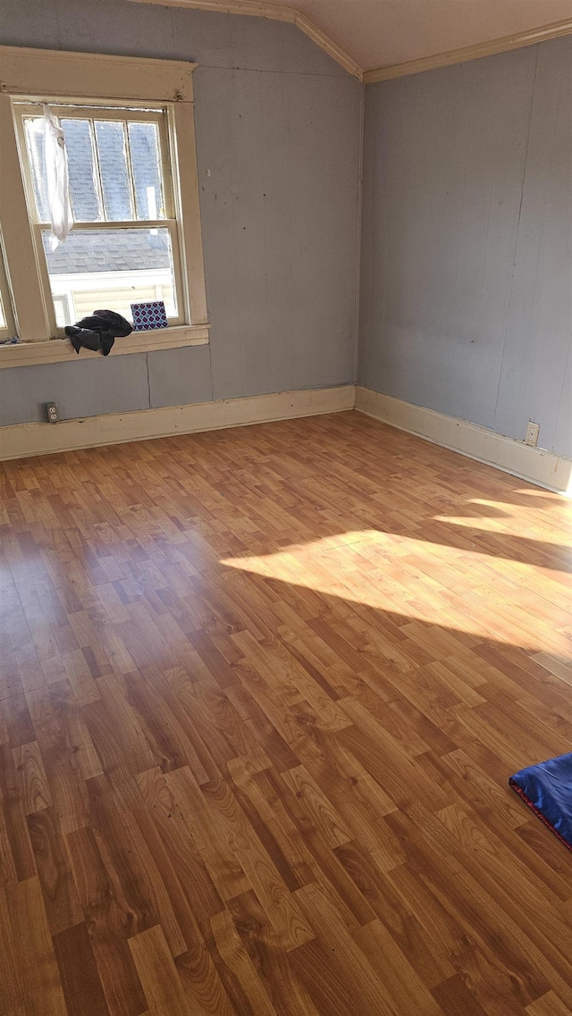 unfurnished room featuring hardwood / wood-style floors and vaulted ceiling