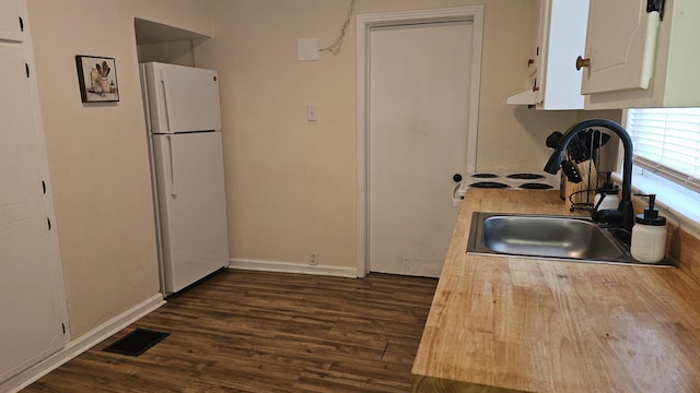 kitchen featuring sink, white cabinetry, white refrigerator, and dark hardwood / wood-style flooring