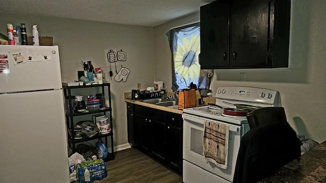 kitchen with a textured ceiling, sink, dark hardwood / wood-style floors, and white appliances