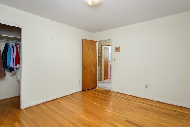 unfurnished bedroom featuring a closet and light wood-type flooring