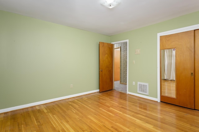 unfurnished bedroom with light hardwood / wood-style flooring and a closet