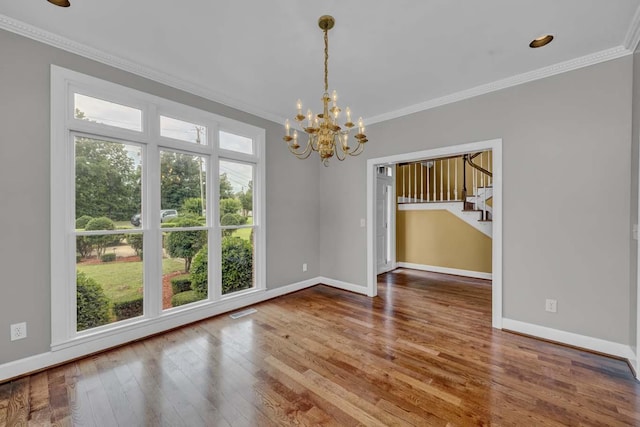 unfurnished dining area featuring a notable chandelier, wood-type flooring, and ornamental molding