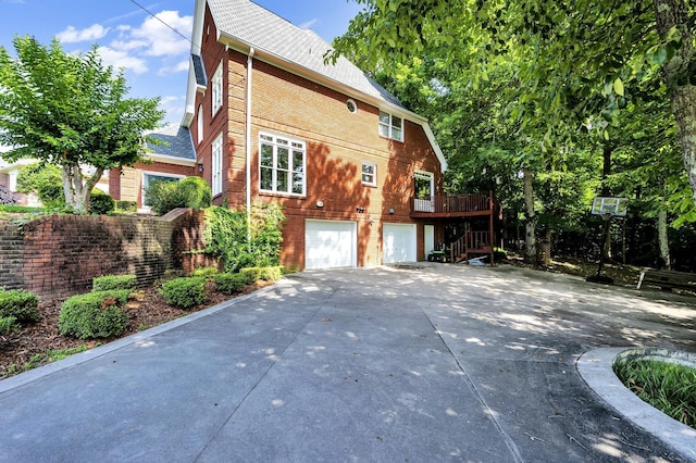 view of side of property with a garage and a wooden deck