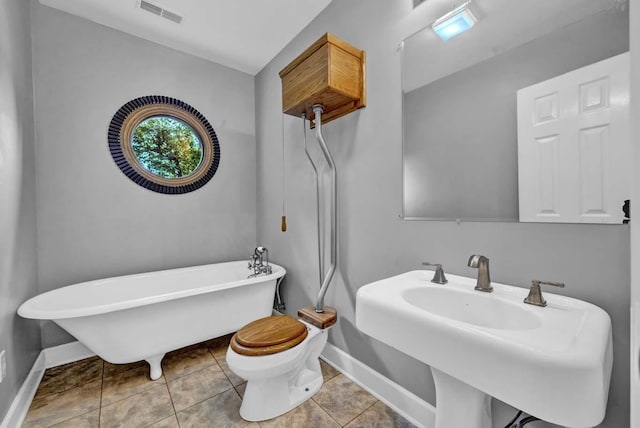 bathroom with tile patterned flooring, toilet, a bathing tub, and sink