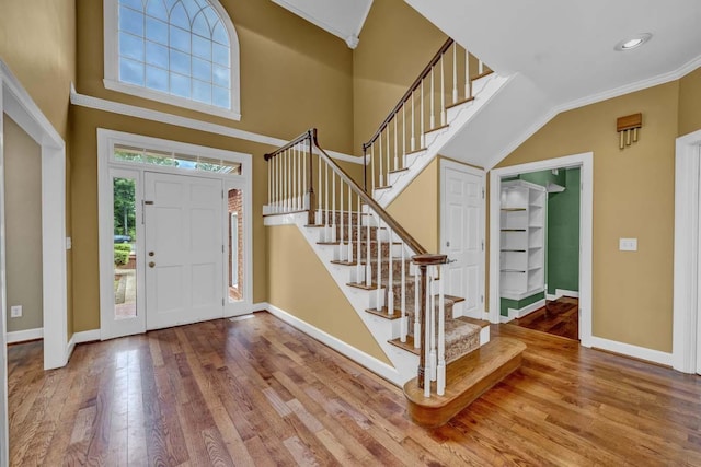 foyer entrance with hardwood / wood-style floors and crown molding