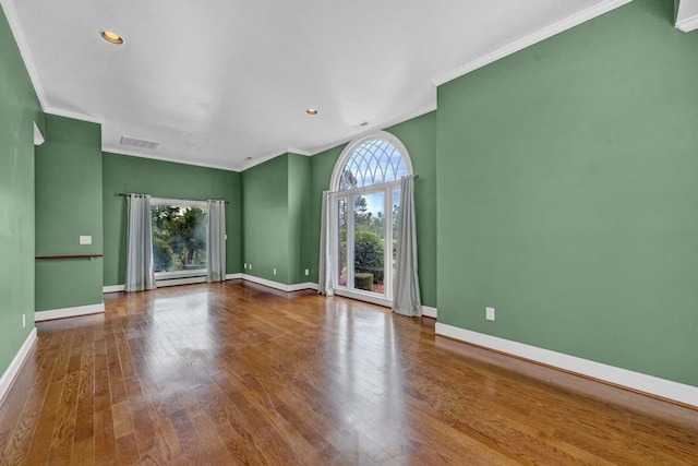 unfurnished room with hardwood / wood-style floors, ornamental molding, and a baseboard radiator