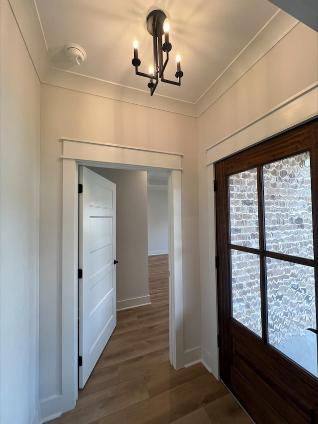 interior space with crown molding, a chandelier, and dark hardwood / wood-style floors