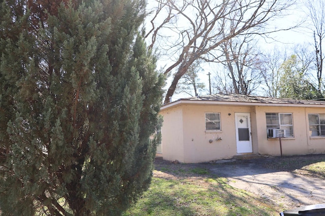 view of front facade featuring cooling unit and stucco siding