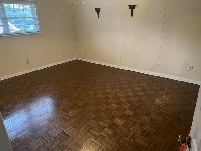 spare room featuring dark parquet flooring