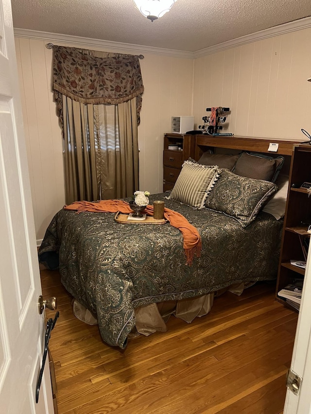 bedroom featuring hardwood / wood-style floors, a textured ceiling, and crown molding