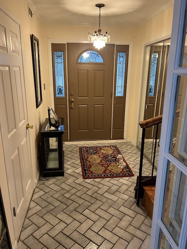 entryway with a textured ceiling and a notable chandelier