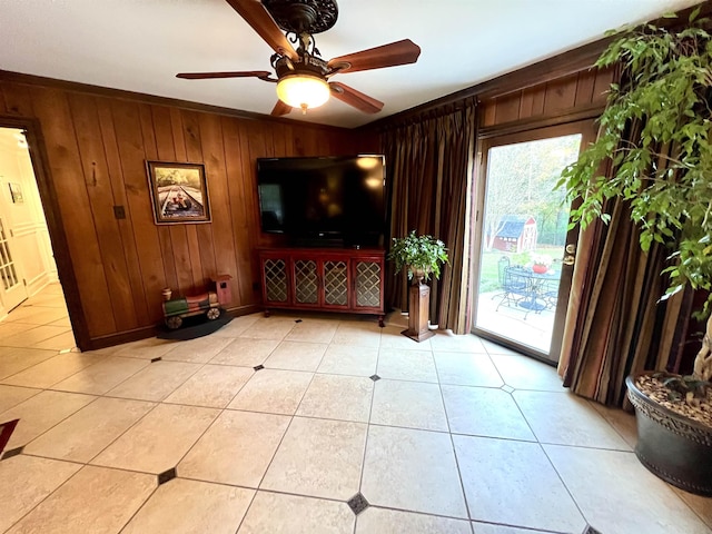 tiled living room with wood walls, crown molding, and ceiling fan