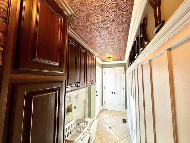 doorway featuring light tile patterned flooring and crown molding