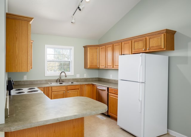 kitchen with lofted ceiling, sink, dishwasher, white refrigerator, and kitchen peninsula