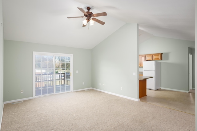 interior space with lofted ceiling, light colored carpet, and ceiling fan