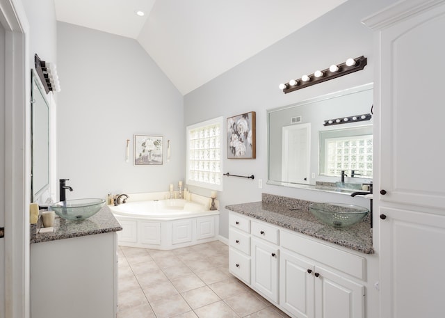 bathroom featuring a healthy amount of sunlight, vaulted ceiling, and a sink