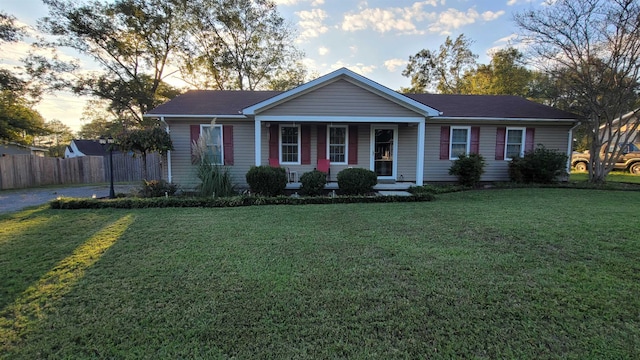 single story home with fence, a porch, and a front yard