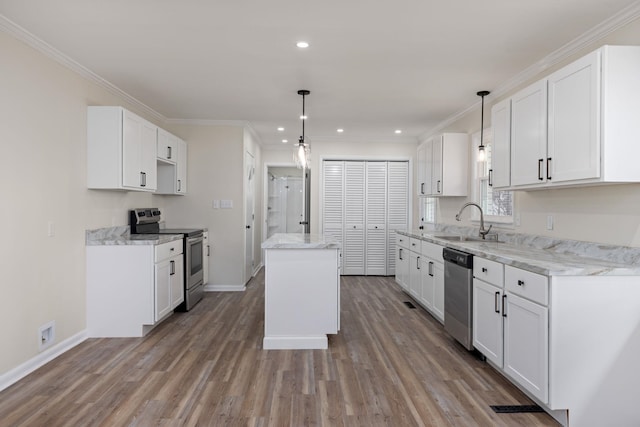 kitchen featuring wood finished floors, a center island, recessed lighting, a sink, and appliances with stainless steel finishes